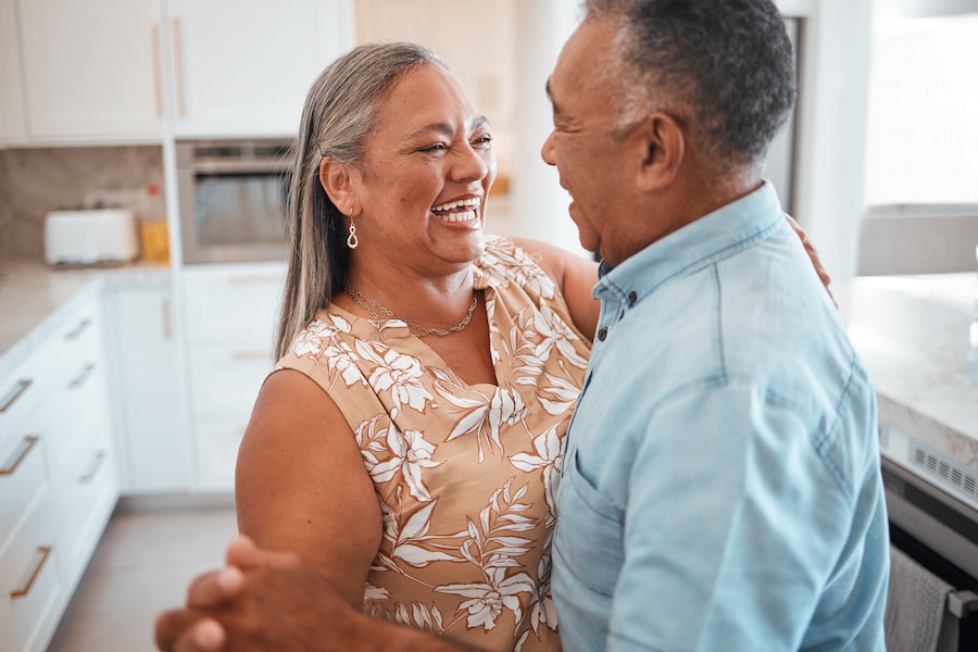 Senior couple dance in the kitchen of their new apartment to celebrate retirement